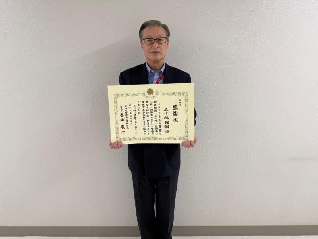 表彰状を持った五十地先生