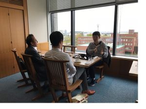 山田学部長、高橋教員に語学研修を学食で報告